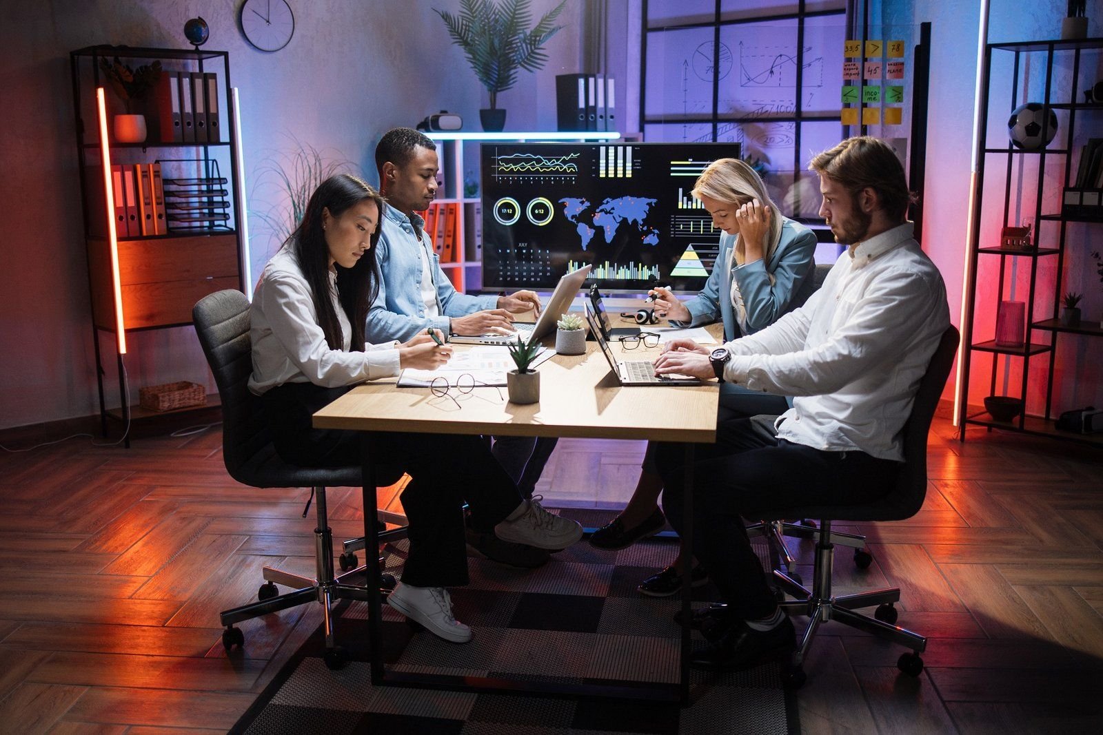 Multiethnic professionals collaborating with laptops and gadgets