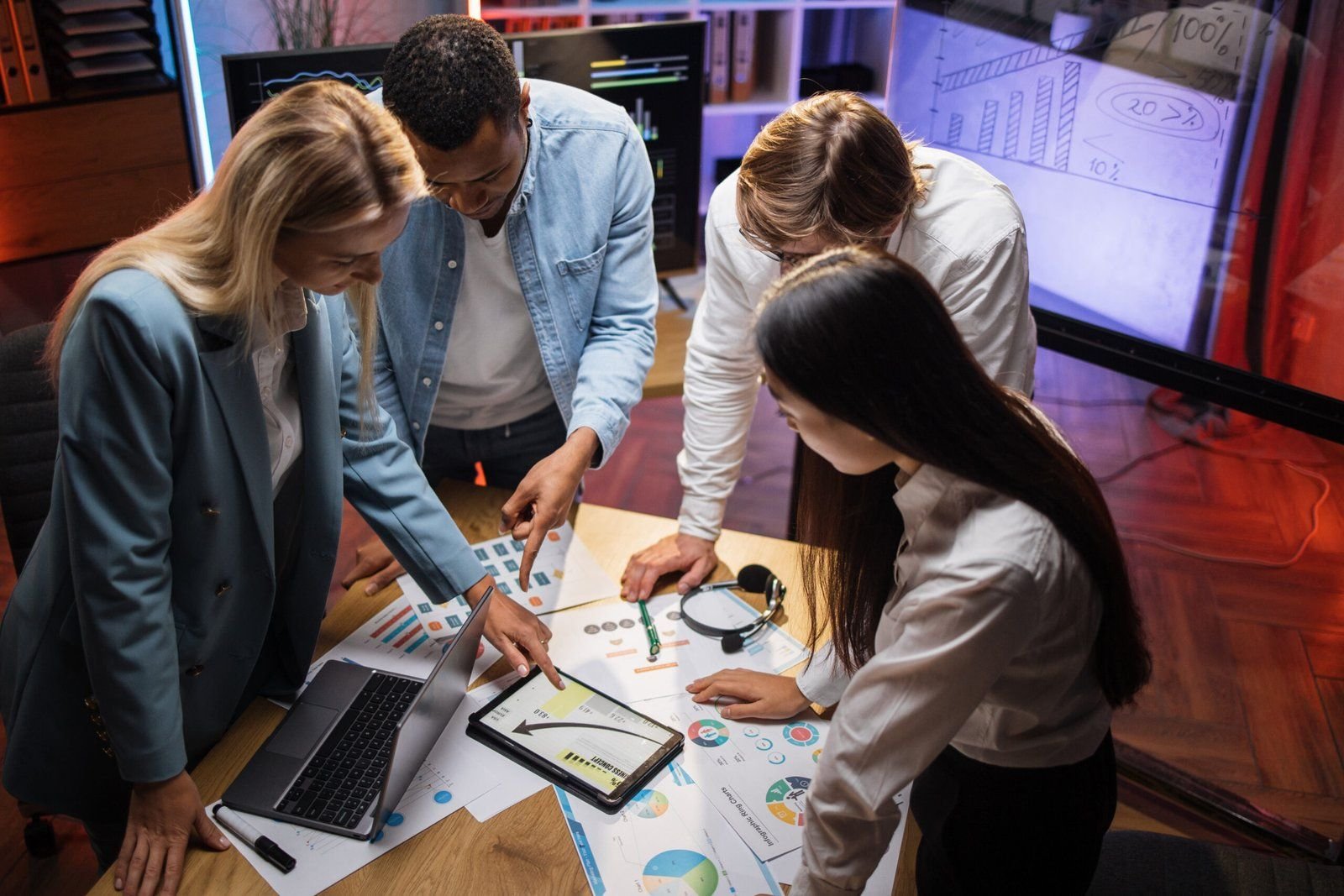Multiracial business partners analysing graphs on a laptop