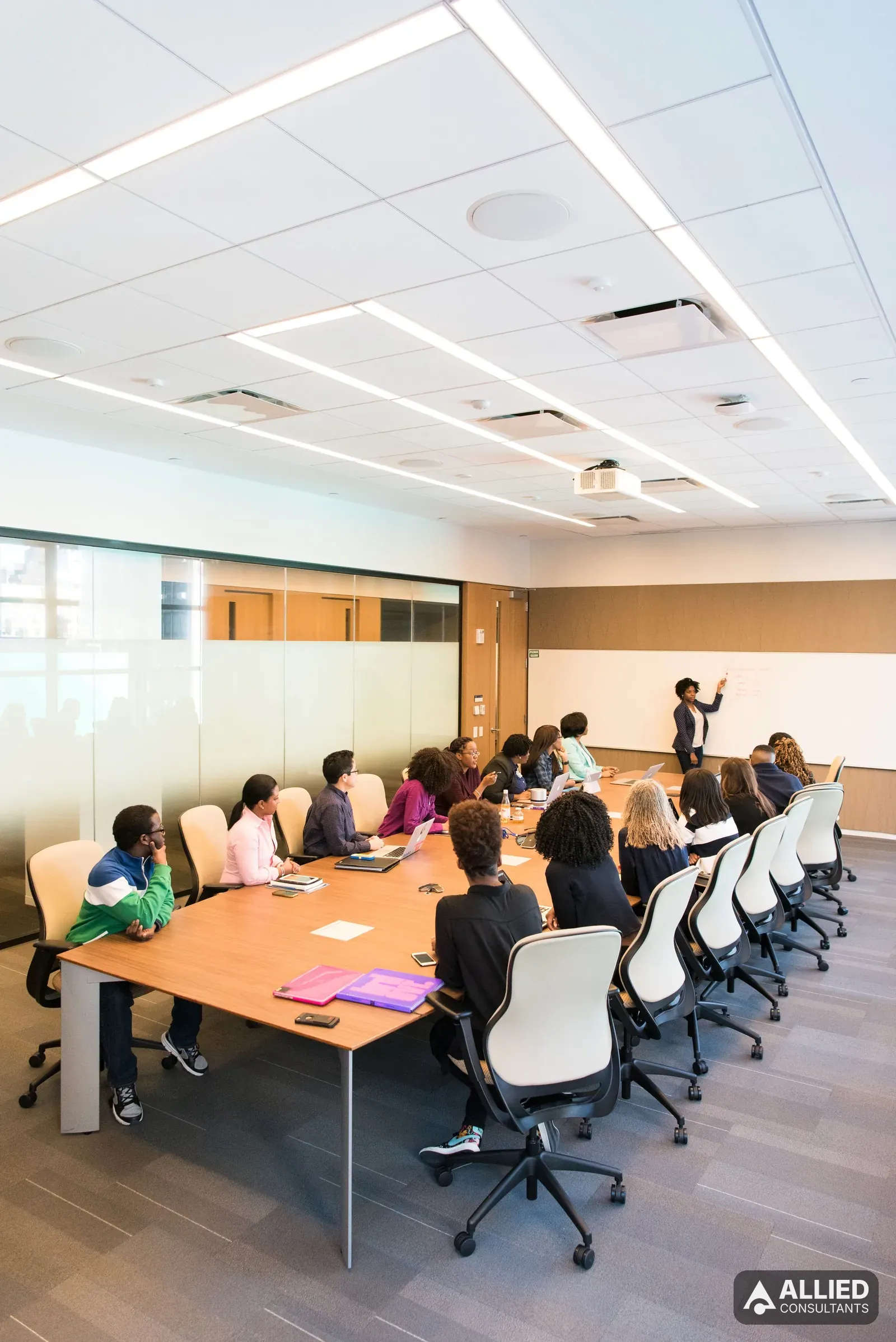 Deal team meeting in a conference room reviewing due diligence findings for an acquisition