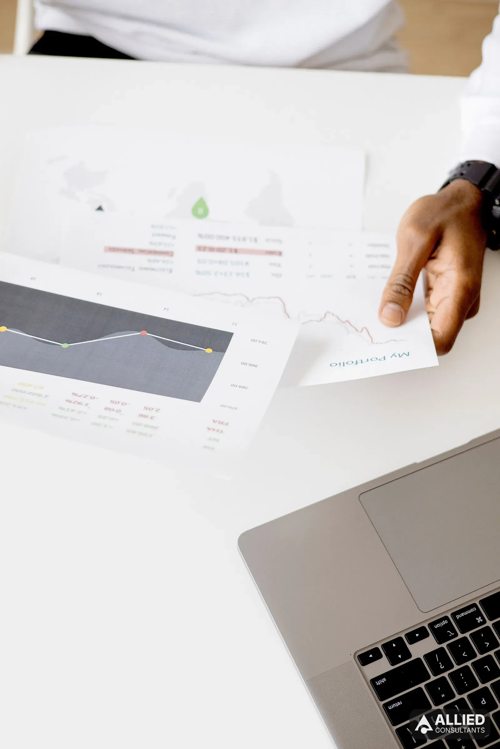 Analyst reviewing a company's financial reports and charts on a laptop during due diligence