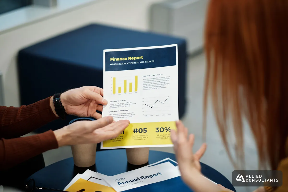 Two colleagues reviewing a printed finance report with charts