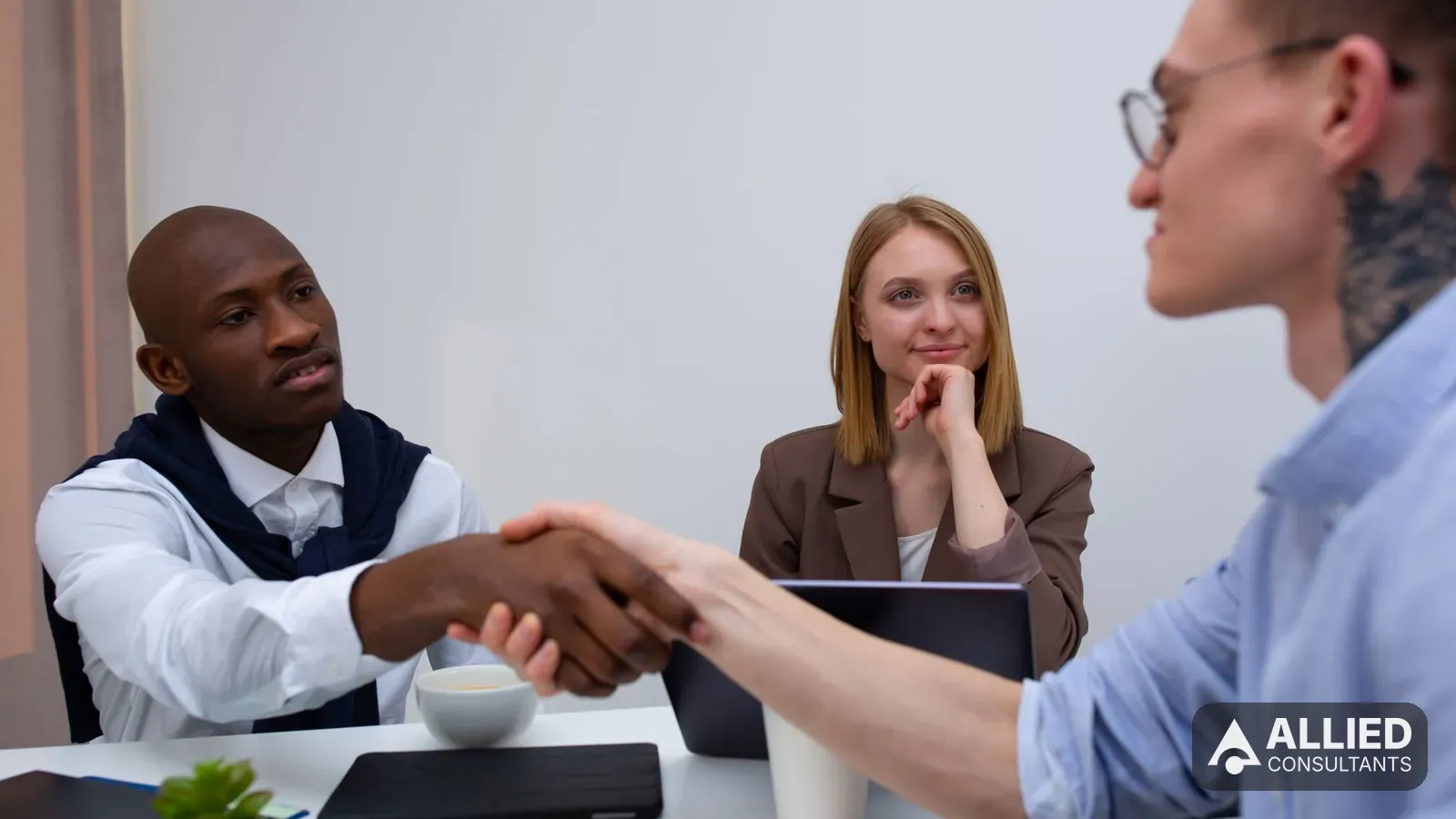 Business owner shaking hands with a buyer in a modern office after agreeing to sell the company